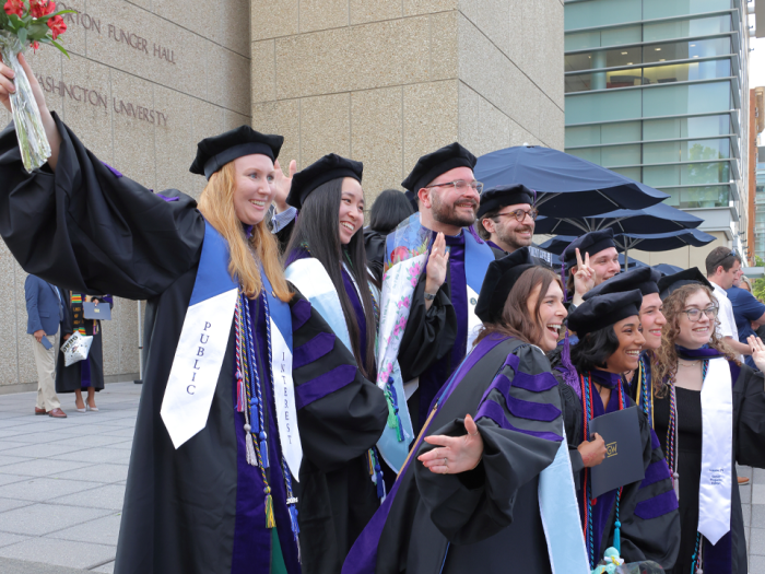 Group of graduates posing for a photo in their regalia.