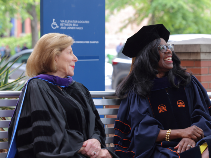 Nina Totenberg and Dean Dayna Bowen Matthew sitting on a bench and smiling