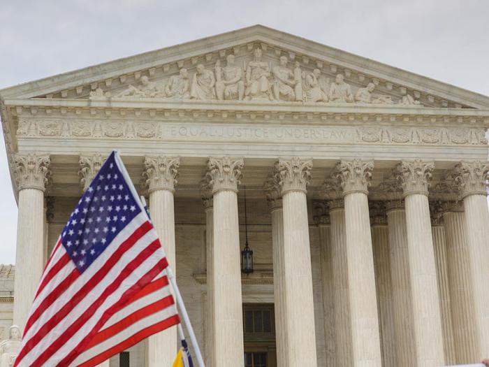US Supreme Court building. The American Flag is visible in front of the building.
