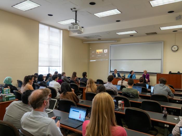 Attendees in front of the panel of speakers
