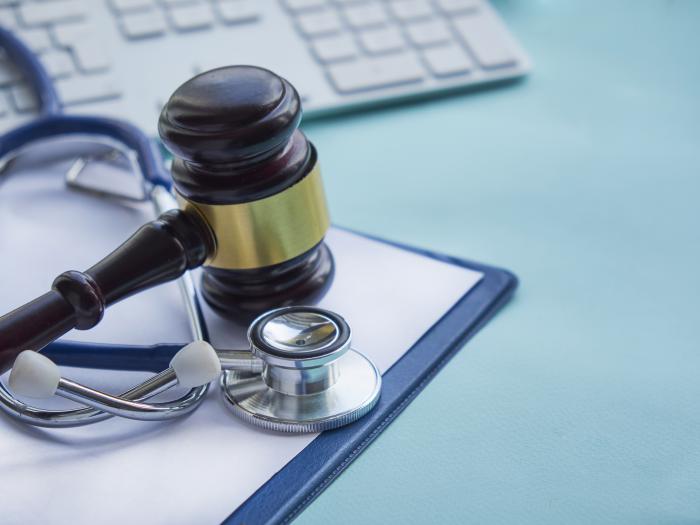 A stethoscope and a gavel on a table.