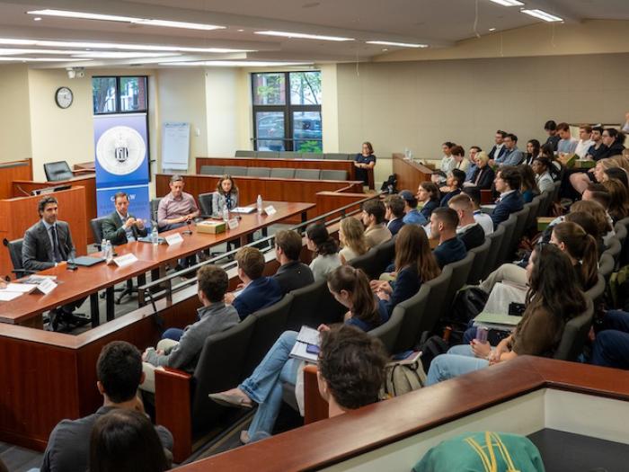 An audience of students listen to National Security law experts talk about careers in National Security law. 