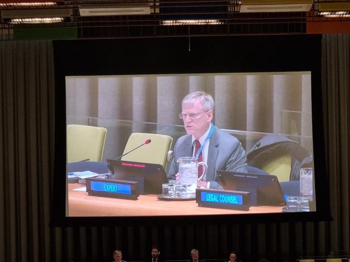 A photo of a projector screen in a room showing GW Law Professor Sean Murphy serving as an expert to the UN Council. 