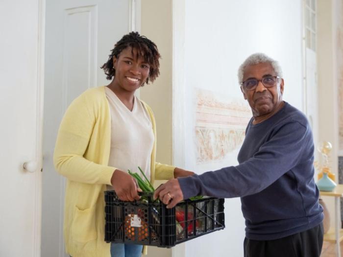 Man handing a woman a box of items