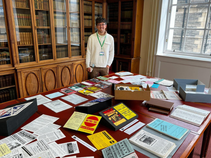 A man standing behind a table with lots of books on it