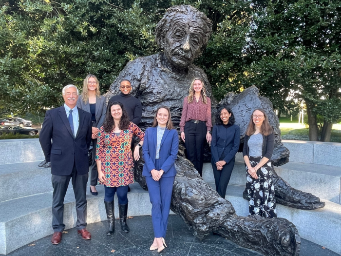 A group of people in front of an Albert Einstein statue