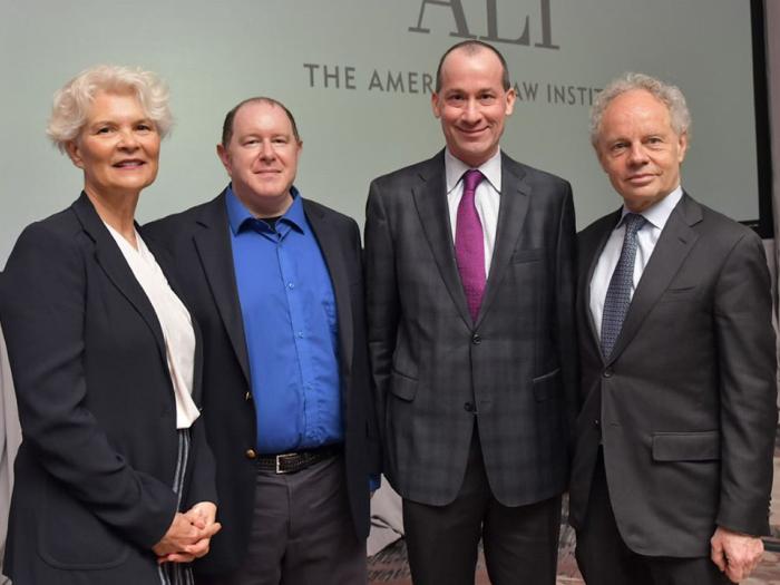 Four people stands together for a photo.