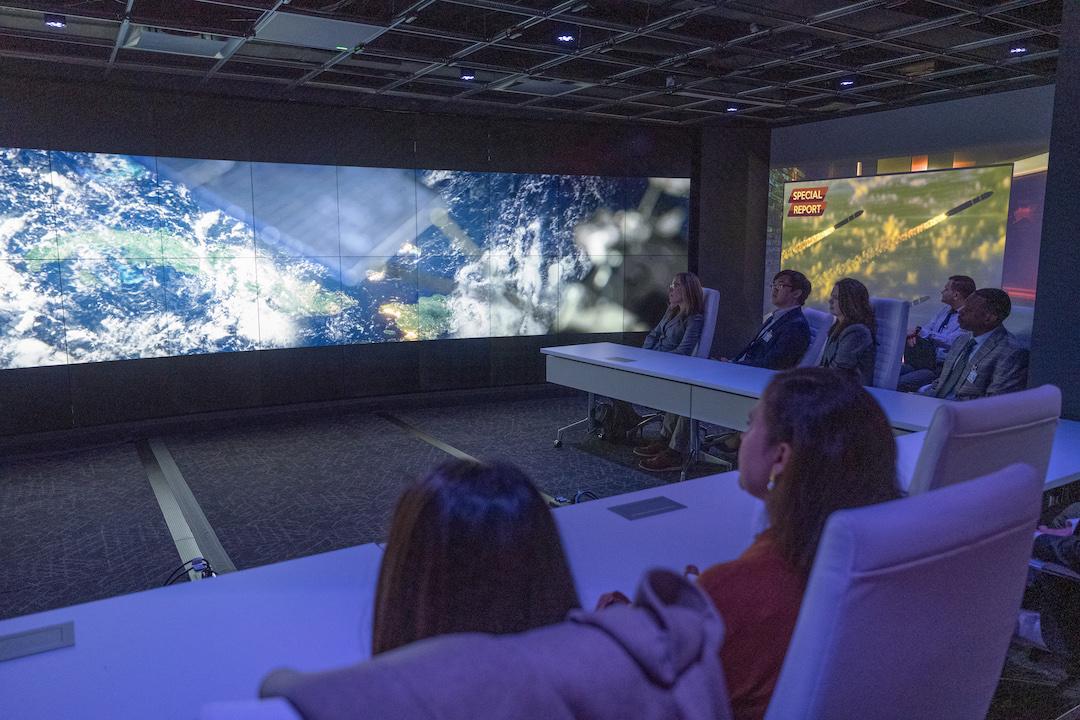 Students watching a video on a big screen