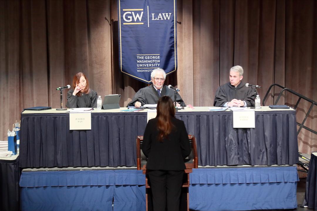 A student speaking to a panel of judges