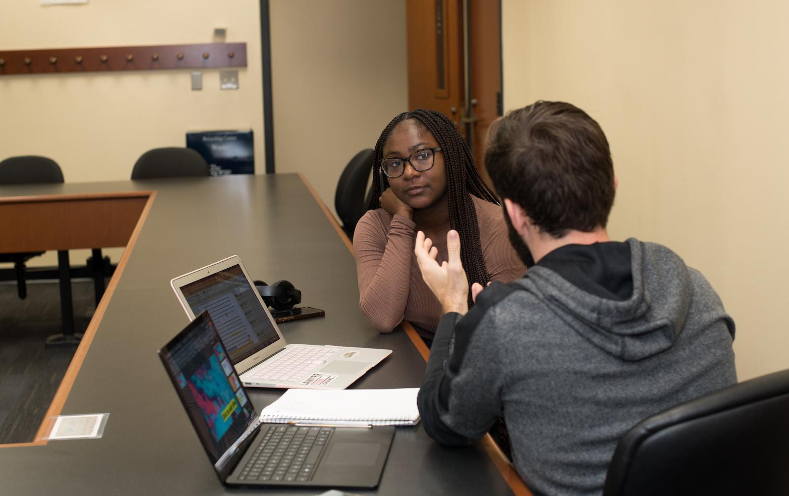 Two students talking in a classroom