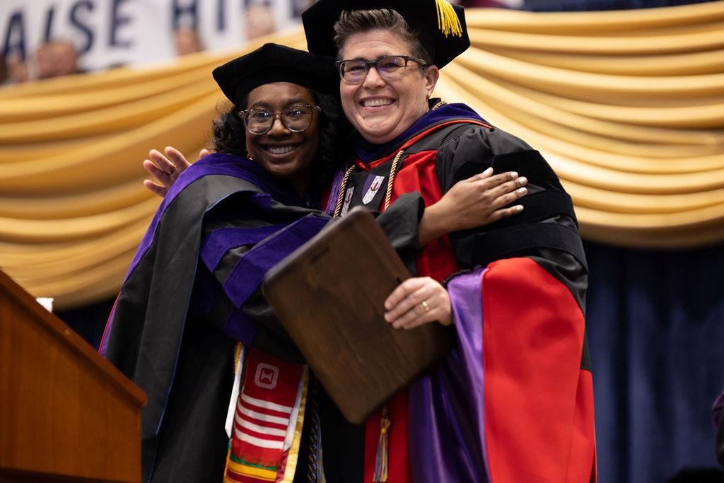 Student Bar Association President Cherissa Lindsay hugs Professor Kathryne Young during the 2025 commencement ceremony.