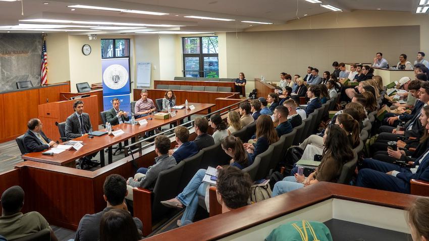 An audience of students listen to National Security law experts talk about careers in National Security law. 