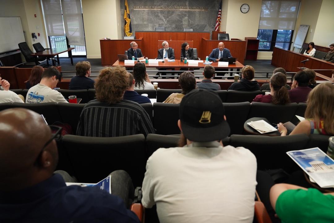 An audience watches GW Law professors talk about the upcoming Supreme Court term in the Burns Moot Court Room.