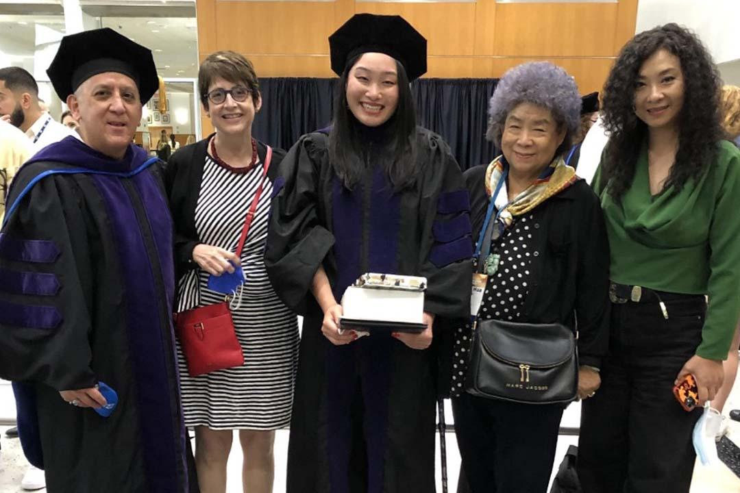 Immigration Clinic Student with professors at graduation