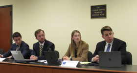 Students sitting at a table all looking intensely in the same direction