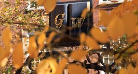 GW Professors Gate with fall leaves in the foreground