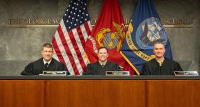 Navy-Marine Corps Court of Criminal Appeals Judges (Colonel) Alison Daly, (Captain) Nathaniel Gross, and (Lieutenant Colonel) Keaton Harrell sit in the judges bench in Burns Moot Court Room.
