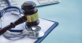 A stethoscope and a gavel on a table. 