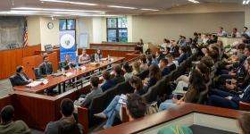An audience of students listen to National Security law experts talk about careers in National Security law. 