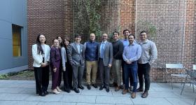 GW Law students pose for a photo with the Hon. Gregory Garre outside of the GW Law Clinics building.